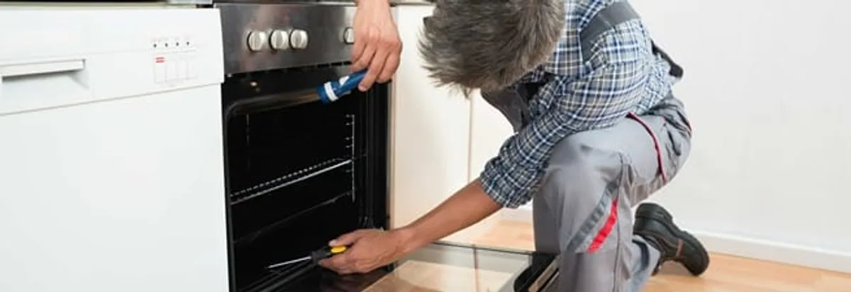 Oven repair technician inspecting and servicing an electric oven in Shreveport, LA